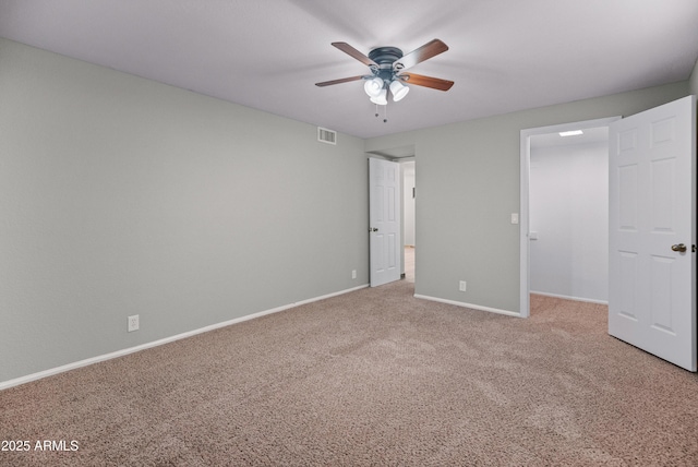 unfurnished bedroom featuring baseboards, a spacious closet, visible vents, ceiling fan, and carpet