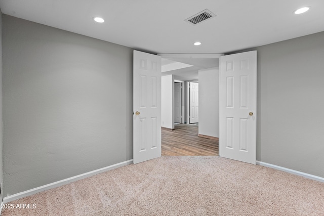spare room featuring recessed lighting, carpet, visible vents, and baseboards