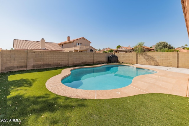 view of swimming pool with a fenced in pool, a fenced backyard, and a lawn