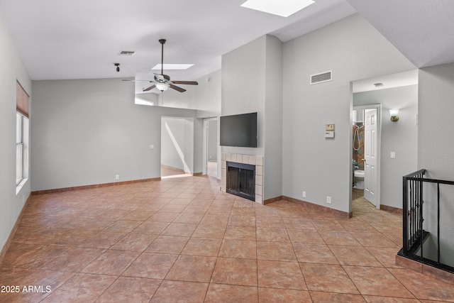 unfurnished living room featuring a fireplace, visible vents, a ceiling fan, and light tile patterned flooring