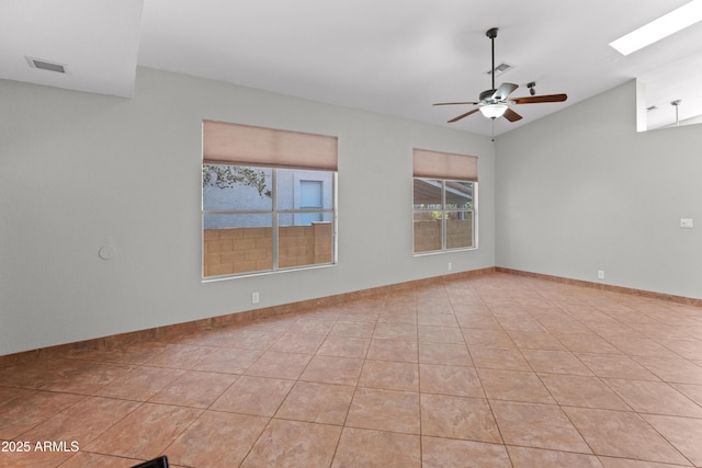 empty room with light tile patterned floors, visible vents, vaulted ceiling, and a ceiling fan