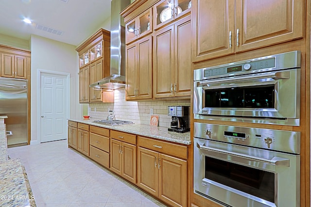 kitchen featuring visible vents, wall chimney range hood, light tile patterned floors, decorative backsplash, and stainless steel appliances