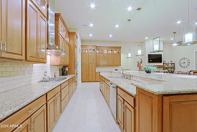 kitchen with a spacious island, glass insert cabinets, stainless steel appliances, wall chimney exhaust hood, and a sink