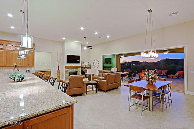 dining area with light tile patterned floors, a ceiling fan, visible vents, a fireplace, and recessed lighting
