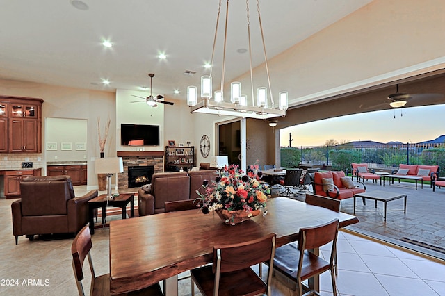 dining space featuring light tile patterned floors, a ceiling fan, visible vents, recessed lighting, and a stone fireplace