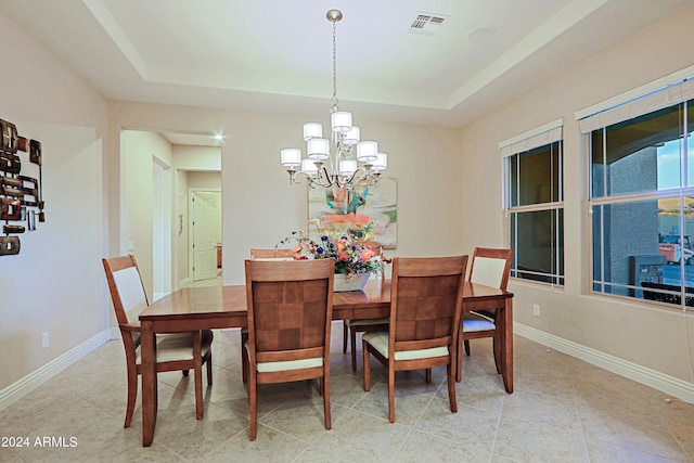 dining room with a tray ceiling, a notable chandelier, baseboards, and visible vents