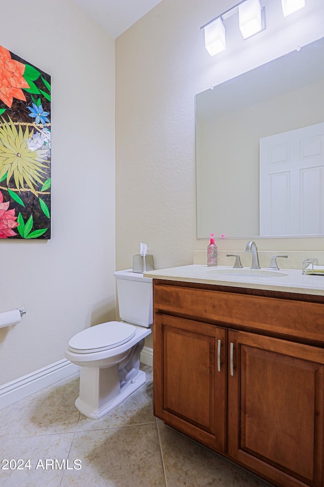 bathroom with tile patterned flooring, toilet, vanity, and baseboards