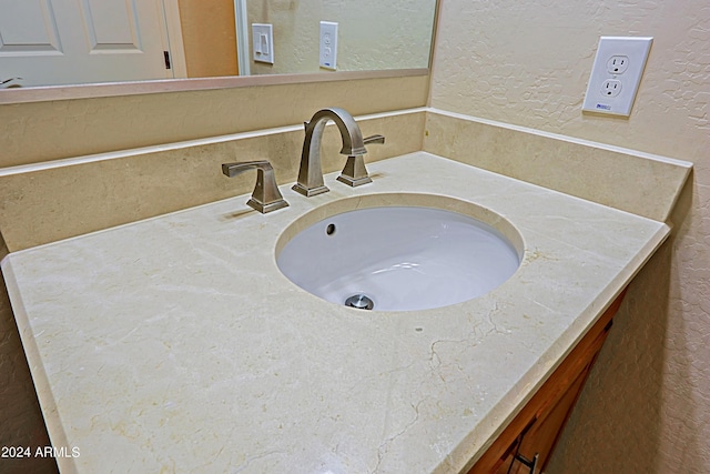 details with vanity and a textured wall
