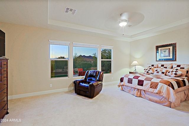 carpeted bedroom with visible vents, ceiling fan, a raised ceiling, and baseboards