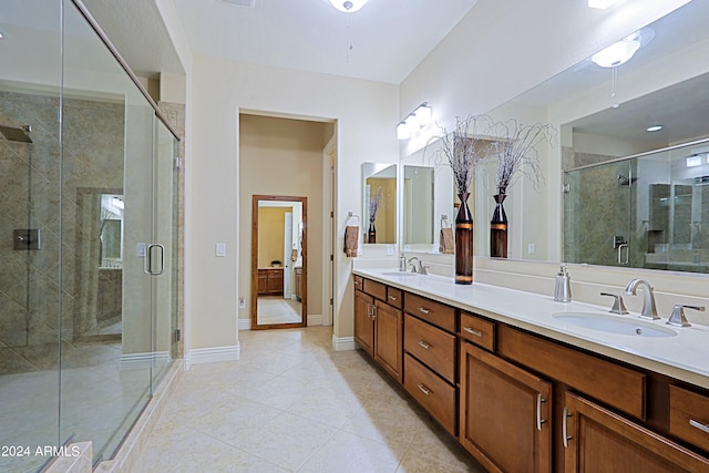 full bath with a sink, baseboards, a shower stall, and double vanity