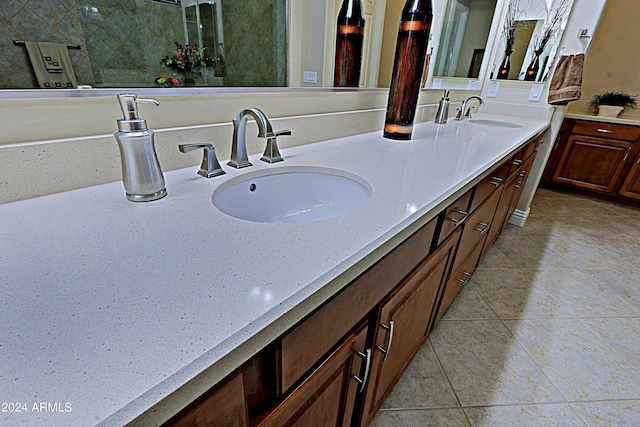 bathroom featuring tile patterned flooring, double vanity, and a sink