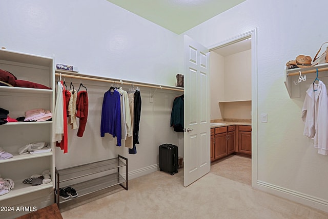 spacious closet featuring light carpet