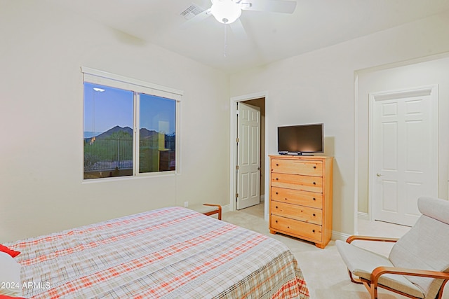 bedroom featuring visible vents, light colored carpet, a ceiling fan, and baseboards