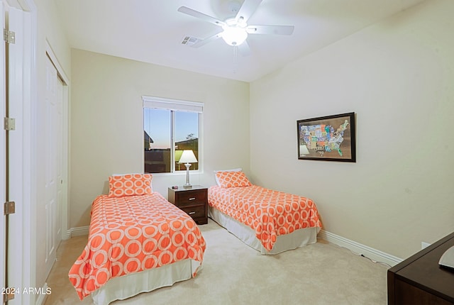 bedroom featuring visible vents, light carpet, a ceiling fan, a closet, and baseboards