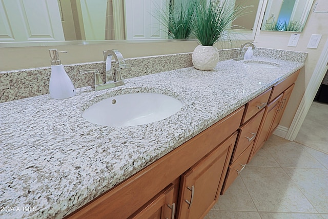 bathroom with a sink, double vanity, and tile patterned flooring
