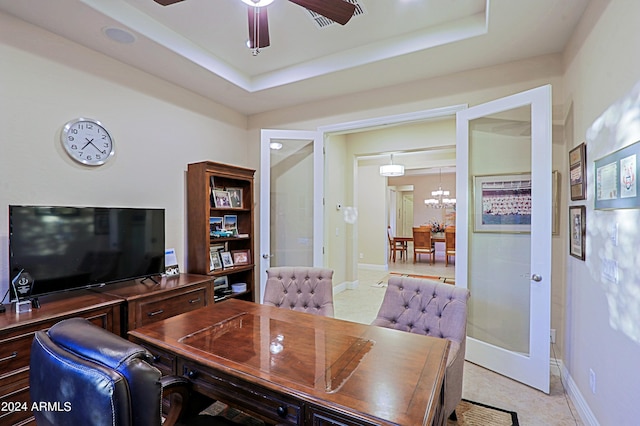 home office with a tray ceiling, baseboards, and ceiling fan with notable chandelier