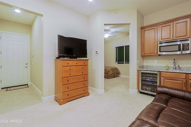 living room featuring a ceiling fan, recessed lighting, wine cooler, baseboards, and light colored carpet