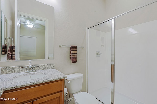full bath featuring vanity, a shower stall, toilet, and ceiling fan