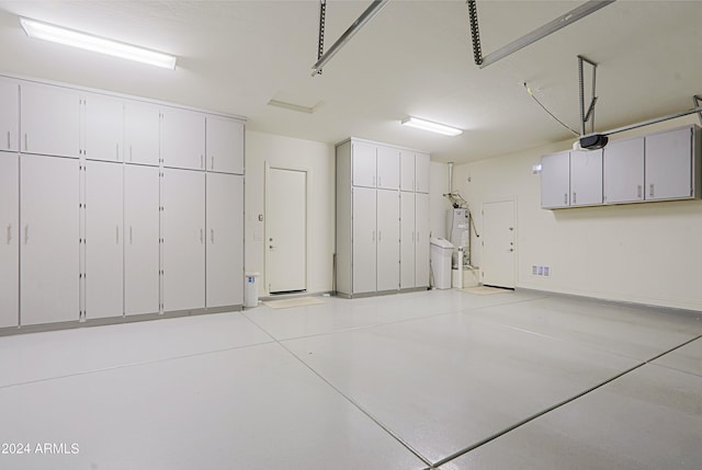 garage with water heater and a garage door opener
