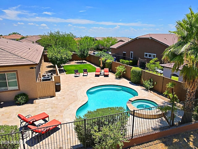 view of pool featuring a pool with connected hot tub, a fenced backyard, and a patio area