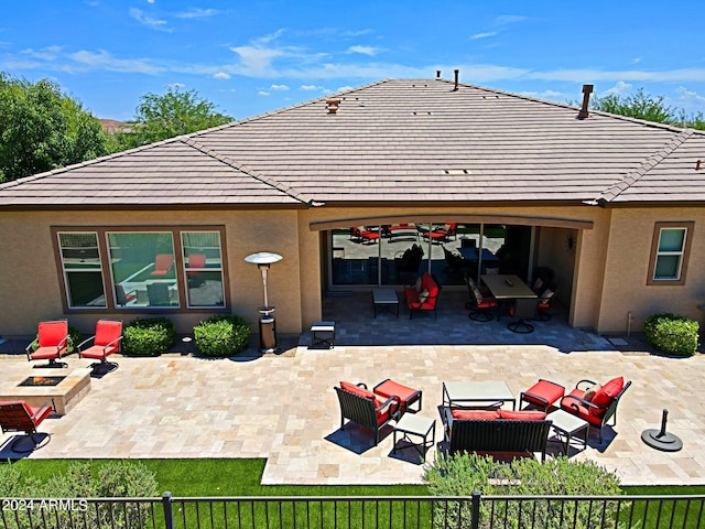 back of property featuring an outdoor living space with a fire pit, a tiled roof, a patio area, and stucco siding