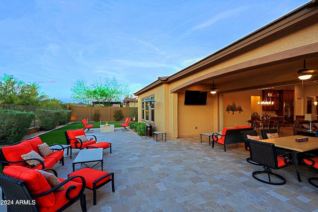 view of patio / terrace featuring an outdoor living space with a fire pit, a fenced backyard, and a ceiling fan