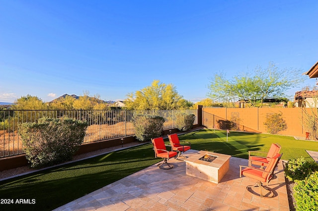 view of patio with a mountain view, a fenced backyard, and an outdoor fire pit