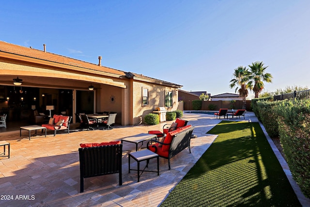 view of patio / terrace with outdoor dining space, ceiling fan, a fenced backyard, and an outdoor hangout area