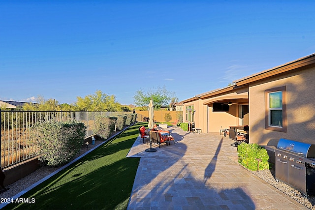 view of yard with a patio area, a ceiling fan, outdoor dining area, and a fenced backyard
