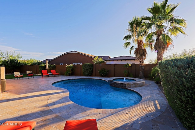 view of swimming pool with a pool with connected hot tub, a patio area, and a fenced backyard