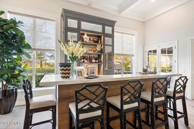 bar with plenty of natural light, beamed ceiling, and coffered ceiling