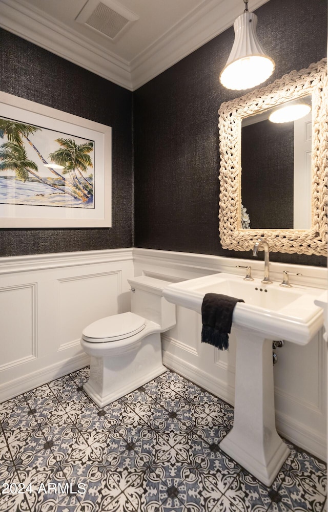 bathroom featuring crown molding and toilet