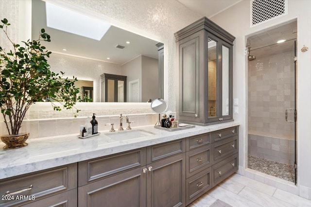 bathroom featuring a skylight, vanity, and an enclosed shower