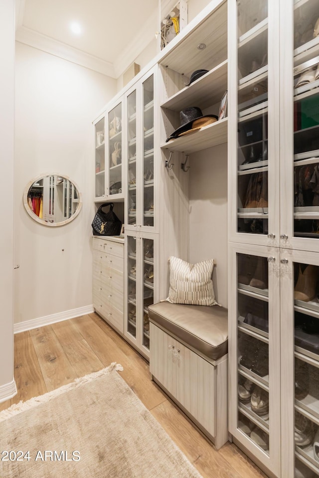 mudroom with light hardwood / wood-style floors and ornamental molding