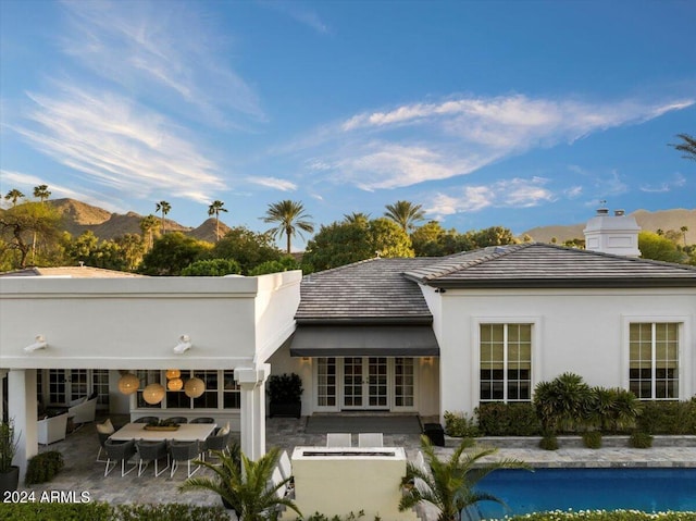 rear view of house with a mountain view, french doors, and a patio