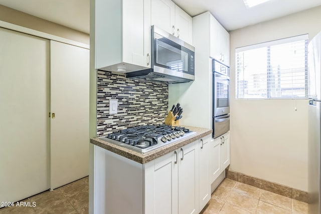 kitchen with a warming drawer, white cabinets, tasteful backsplash, and appliances with stainless steel finishes