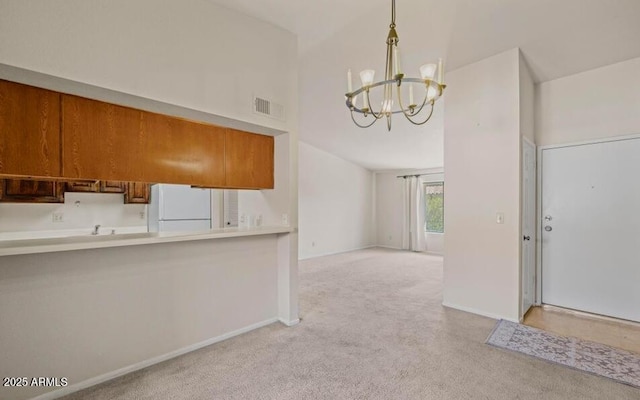 1402 E Guadalupe Rd Unit 215, Tempe, AZ 85283 - kitchen featuring freestanding refrigerator, light carpet, a chandelier, brown cabinetry, and baseboards