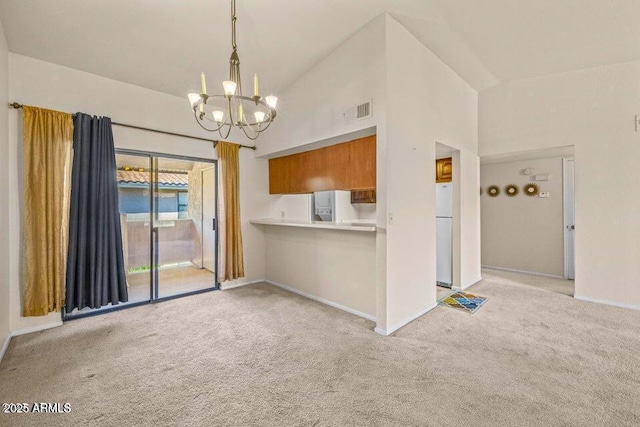 1402 E Guadalupe Rd Unit 215, Tempe, AZ 85283 - kitchen with light colored carpet, a chandelier, freestanding refrigerator, baseboards, and high vaulted ceiling