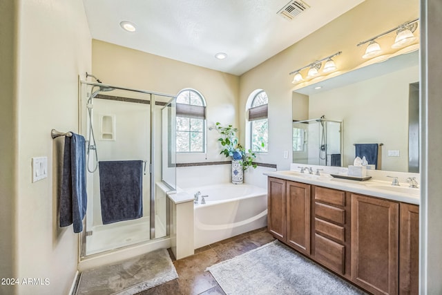 bathroom featuring vanity and independent shower and bath