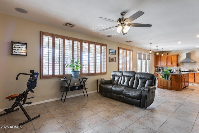 living area with a wealth of natural light, visible vents, baseboards, and light tile patterned floors