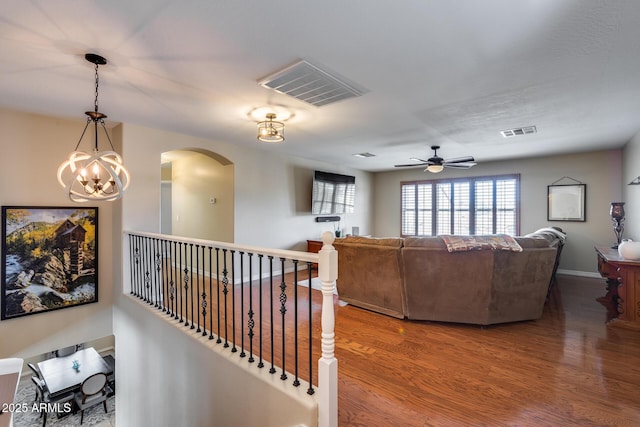 living room with visible vents, arched walkways, baseboards, and wood finished floors