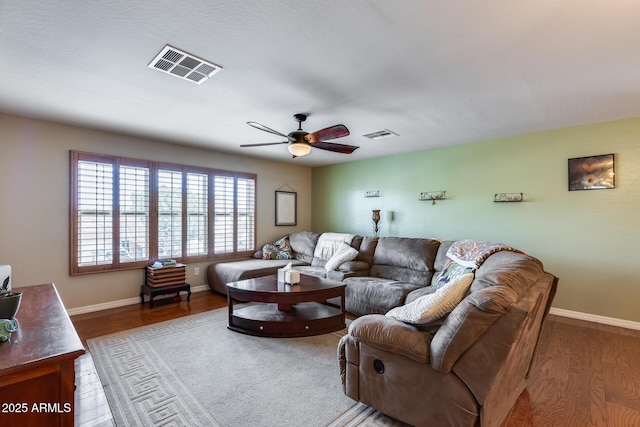 living area with visible vents, baseboards, and wood finished floors