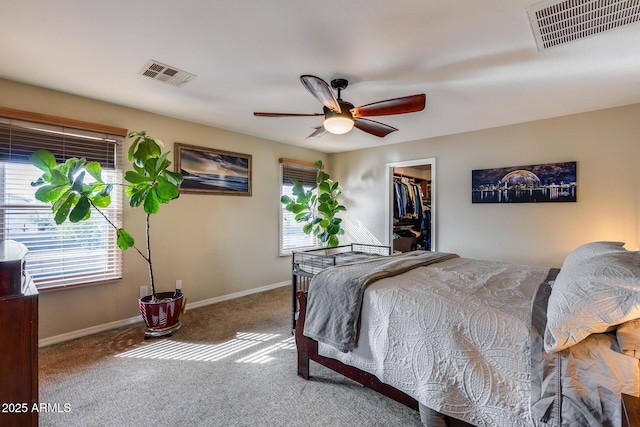 bedroom with a walk in closet, multiple windows, and visible vents