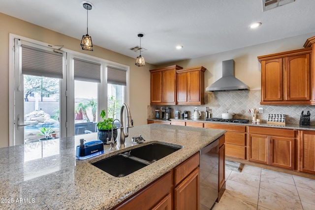 kitchen with visible vents, wall chimney range hood, stainless steel gas cooktop, dishwashing machine, and a sink