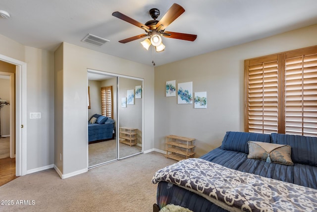 carpeted bedroom featuring visible vents, baseboards, a closet, and a ceiling fan