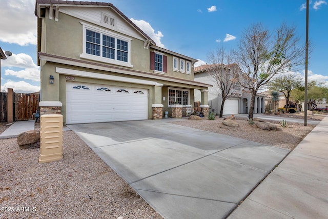 traditional-style home with fence, stucco siding, concrete driveway, a garage, and stone siding