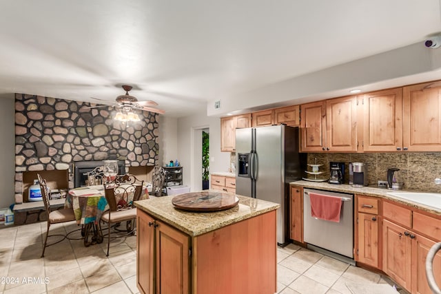 47012 N New River Rd, New River, AZ 85087 - kitchen with appliances with stainless steel finishes, light tile patterned flooring, a center island, a sink, and light stone countertops