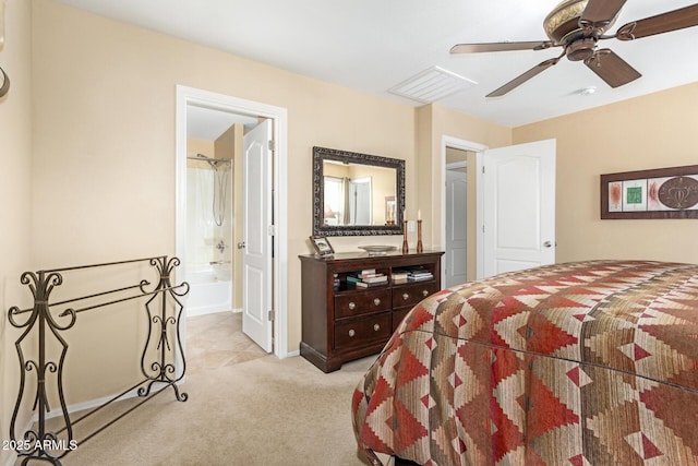 bedroom with ensuite bath, light colored carpet, and ceiling fan