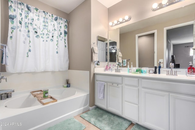 bathroom with tile patterned floors, a tub, and vanity