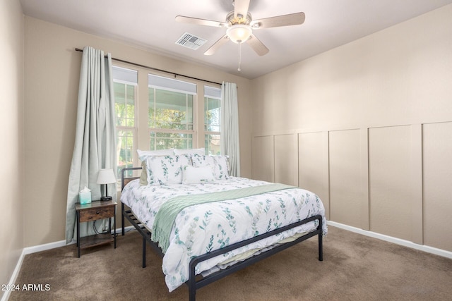 bedroom with carpet flooring, ceiling fan, and multiple closets